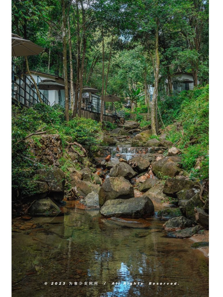 Stream with rocks and buildings nearby