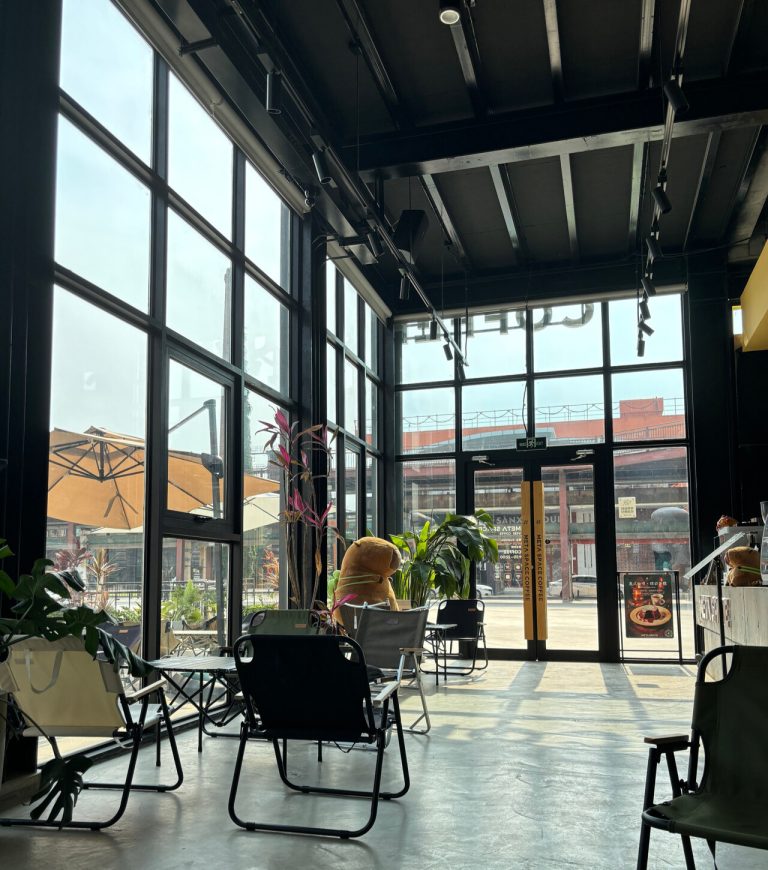 Industrial-style cafe interior with plants and seating