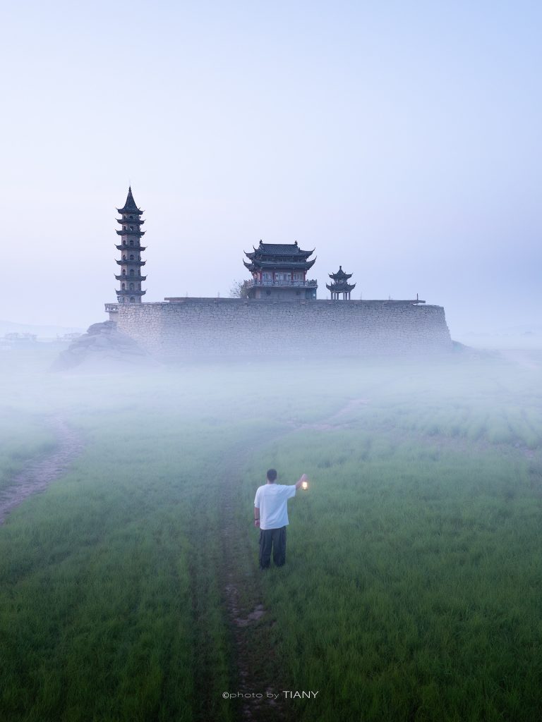 Ancient pagoda emerging from morning mist in Yongquan