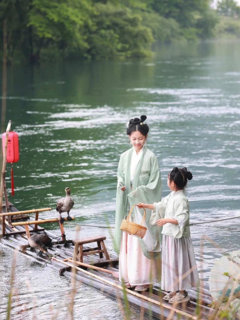 Hanfu-clad figures on bamboo raft