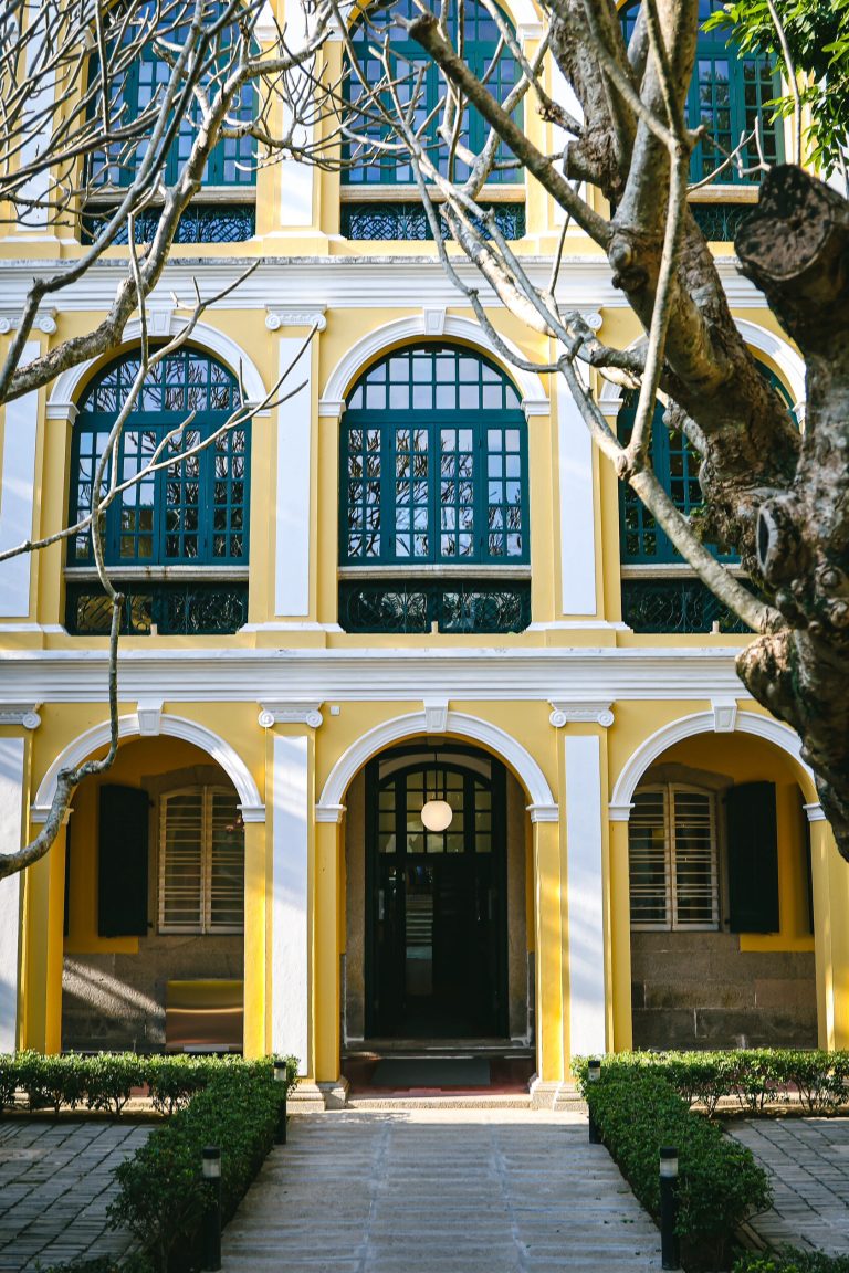 Yellow colonial building with blue accents