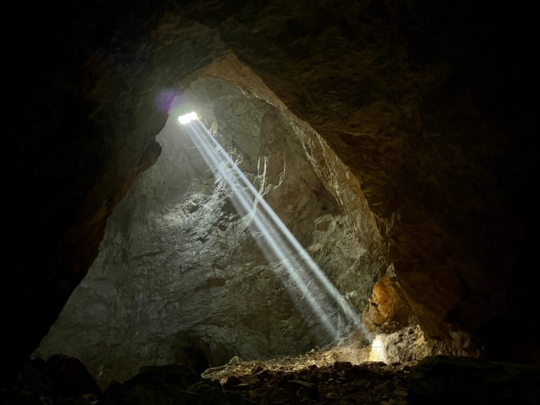 Cave interior with light beams illuminating the rocks