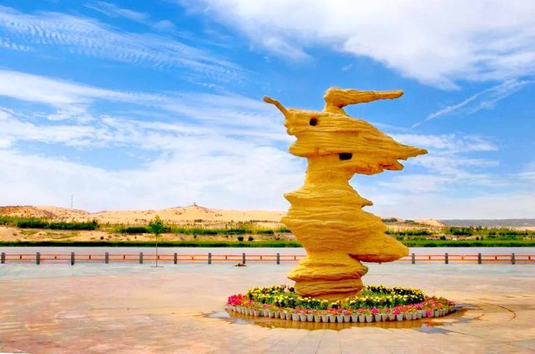 Large yellow sculpture with desert backdrop