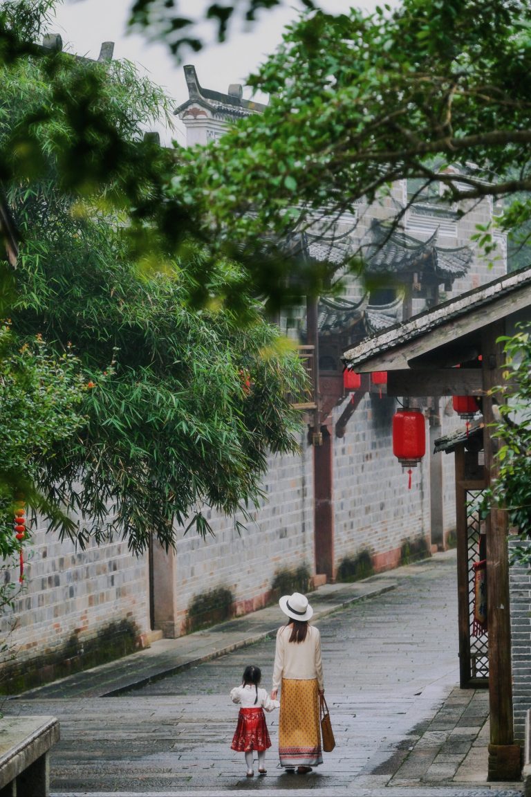 Quiet stone path flanked by traditional buildings with red lanterns