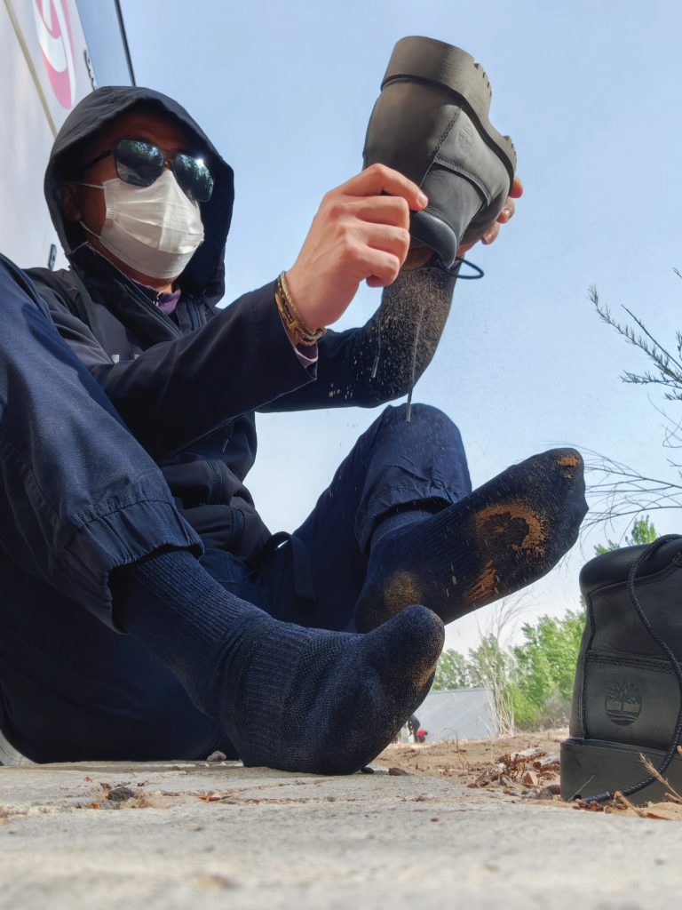 Person inspecting a muddy shoe on a hard surface