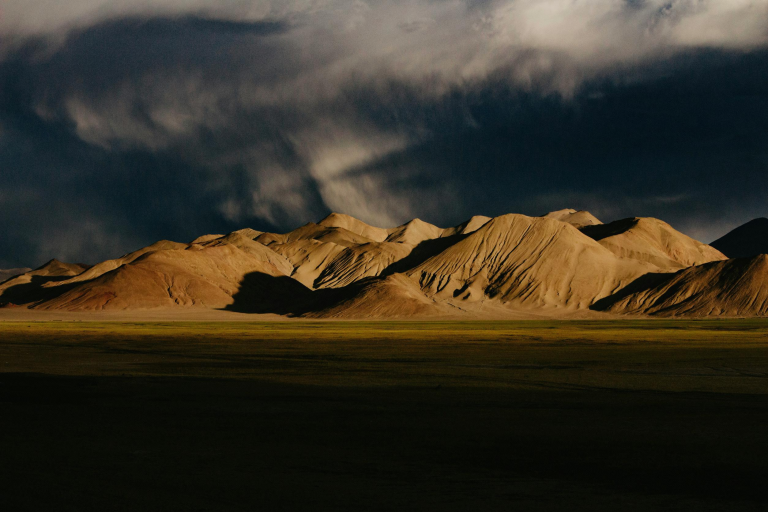 Land Cruisers crossing grassland near Namtso