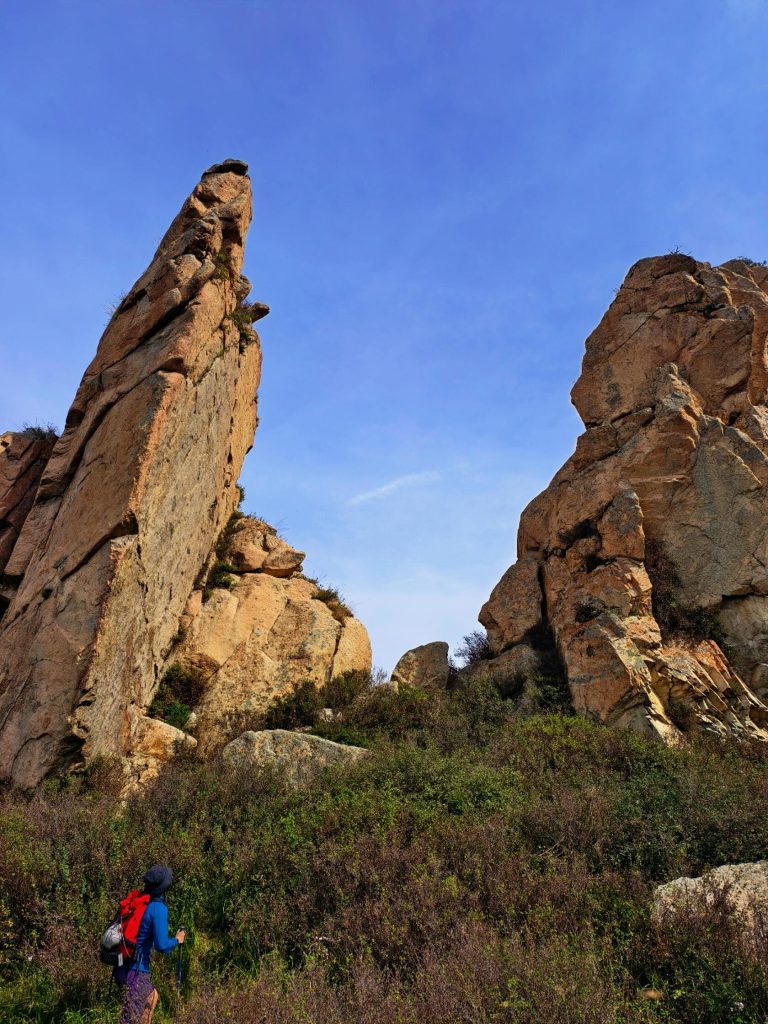 Hiker admiring unique rock formations in Laiyuan, Jing-Jin-Ji Hiking Adventure